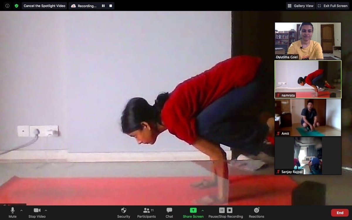 A Zoom class — a student in Crow pose in the main window, the rest of the batch tiled down the side.