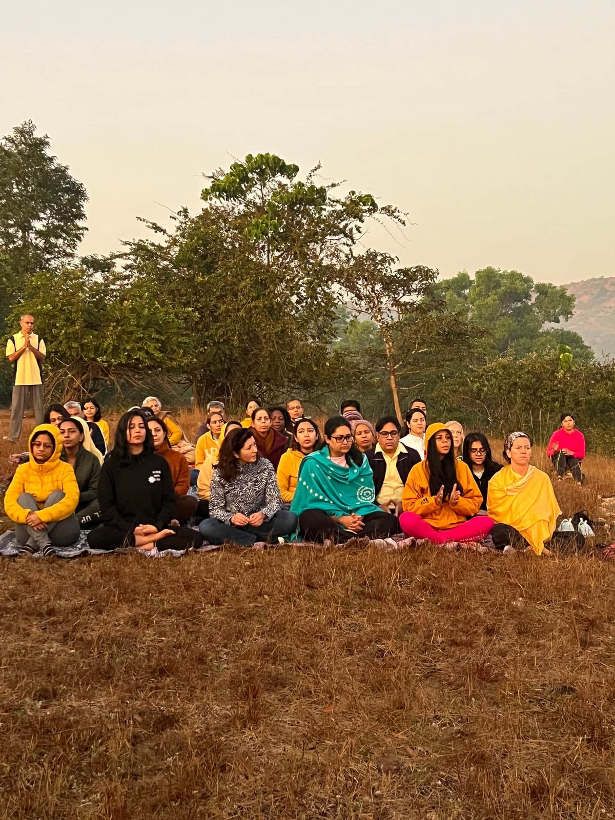 Retreat participants seated for morning meditation in the open air