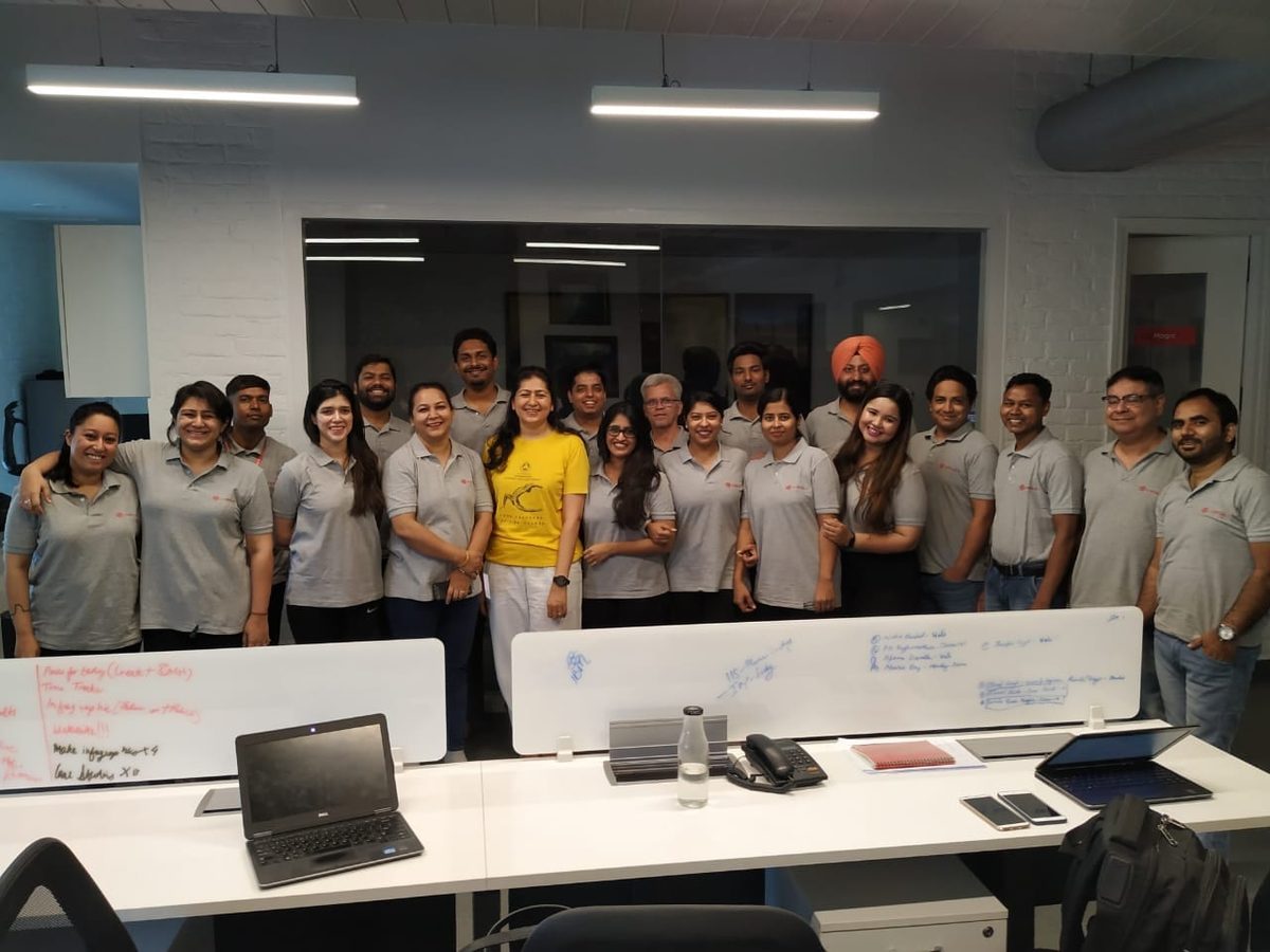 A company team photographed with their teacher