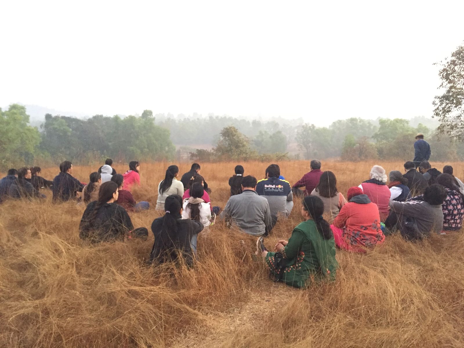 Retreat group sitting together in a meadow with the western ghats behind